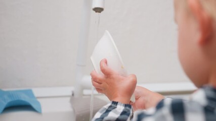 Close up of kid holding plate under running tap getting water and turning stream into sink with small hands showing learning responsibility hygiene and domestic practice - Powered by Adobe