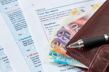  United Kingdom tax settlement. Tax forms. UK money wallet. Financial business concept. Filling out a form. Close up
