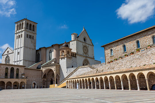 Basilica of St. Francis of Assisi in Umbria, Italy. The stunning architecture of this historical site is highlighted against a bright blue sky on a sunny day.