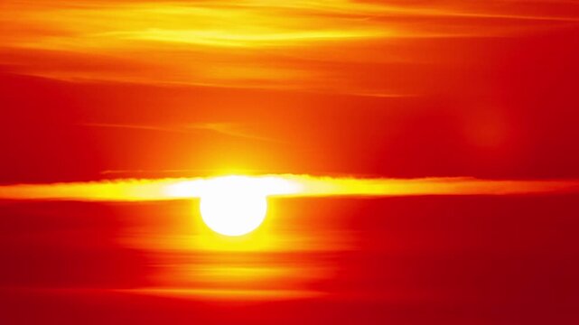 A timelapse shows a fiery sunset displaying vibrant red hues over a dark industrial silhouette. The factory shapes emphasize concepts of global warming and environmental impact.