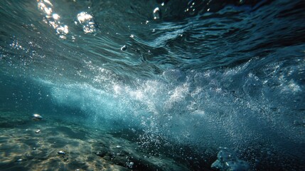 Sunlight filters through the ocean surface creating a shimmering effect as bubbles rise. Clear water reveals sandy ocean floor along with moving waves and vibrant aquatic life.