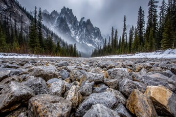 Majestic mountain peaks shrouded in mist, rising above a rocky riverbed with dense forest on both sides, creating a serene and awe-inspiring landscape, with snow covered.