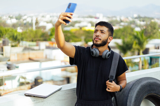 Conectividad urbana: Joven con tecnolog&iacute;a en un entorno citadino