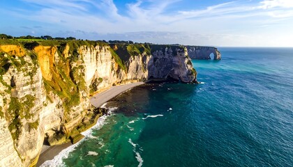 A stunning aerial view showcases dramatic coastal cliffs meeting a clear, turquoise ocean. The scene is bathed in sunlight, with a natural arch