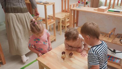 preschool teacher drops food for snails while children gather around table, observing with excitement and curiosity during hands on nature lesson in bright classroom - Powered by Adobe