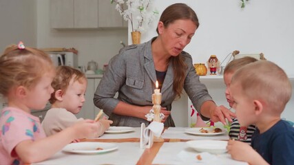 Educator leaning toward children talking attentively while they eat together in cozy kindergarten classroom filled with soft daylight, wooden tables, plants, and calm atmosphere - Powered by Adobe