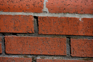 Close-Up of Red Brick Wall Texture, Weathered Brick Surface with Mortar Lines, Rough Masonry Background with Cracked Brick