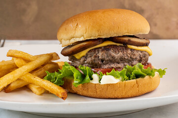cheese burger top with  mushrooms with french fries