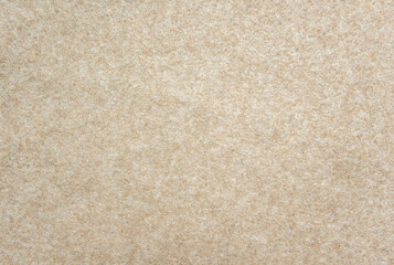 Beige felt texture background. Soft fabric surface with fuzzy fibers, warm neutral textile material for design or craft backdrop.