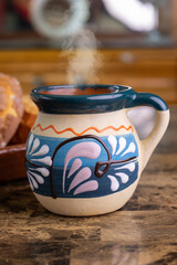 Mexican hot beverage with steam rising from a colorful ceramic mug