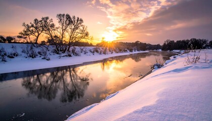 A serene winter landscape. A river reflects the golden hues of the setting sun. Snow blankets the banks, and trees stand silhouetted against the sky