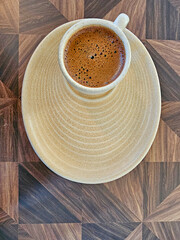 Cup of coffee on a wooden table. View from above.