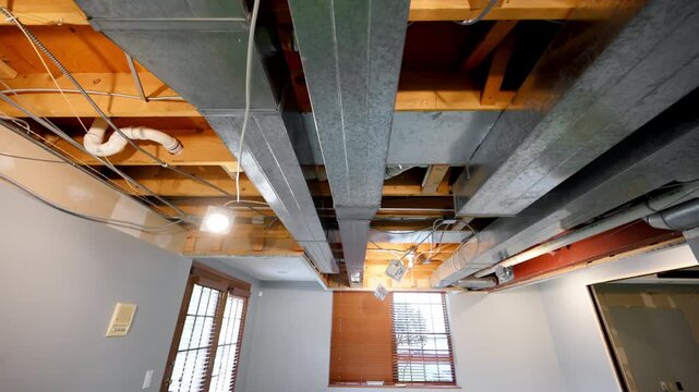  hvac heating, ventilation, air conditioning system under the ceiling in the empty basement room in residential house under renovation. View from below. 