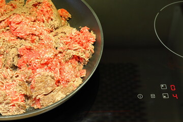 Minced meat in a frying pan on stove. Cooking concept.