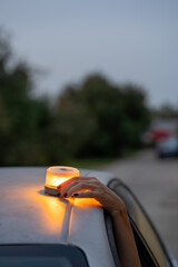 v16 Woman placing emergency beacon light on broken down car
