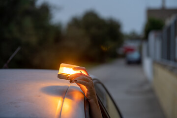 v16 Woman placing emergency beacon light on broken down car