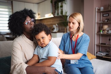 Doctor examining child patient at home