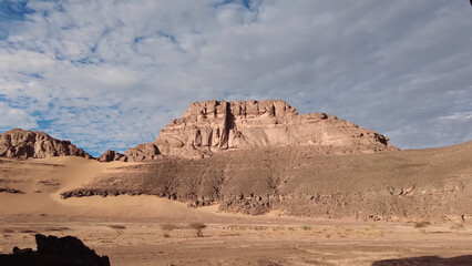 A trip to Sahara desert in Algeria. Beautiful 
african travel photo. Sandy landscapes, mountains, rocks,
dunes, and nature. Summer vacation in arab country.