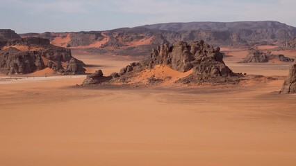 Naklejka premium A trip to Sahara desert in Algeria. Beautiful african travel photo. Sandy landscapes, mountains, rocks, dunes, and nature. Summer vacation in arab country.