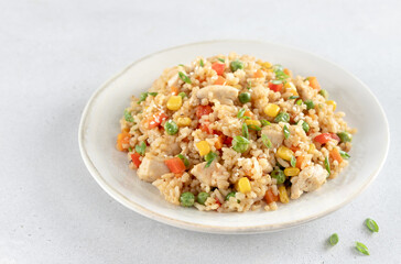Fried rice with chicken and vegetables carrots ,peppers, corn, green peas on white background. 