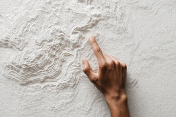 Hand pointing at textured topographic map minimal style neutral color tactile navigation exploration curiosity close up modern design creative concept planning