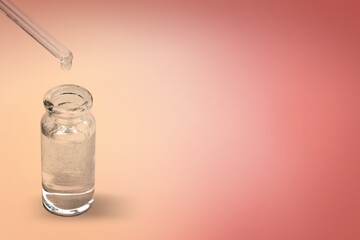 A drop falls from glass pipette in medical glass bottle