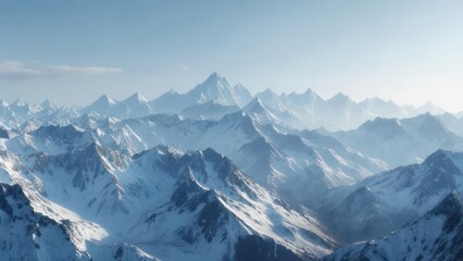 Snowy peaks of a vast mountain range under a clear, bright blue sky, shrouded in mist