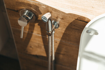 Hygiene bidet shower on wall near toilet in house