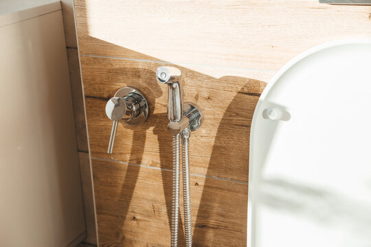 Hygiene bidet shower on wall near toilet in house