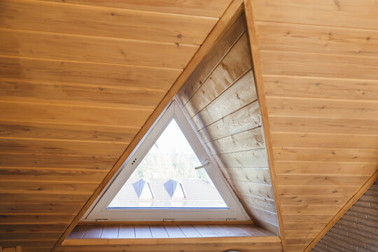 A triangular dormer window on the attic floor, viewed from inside the house