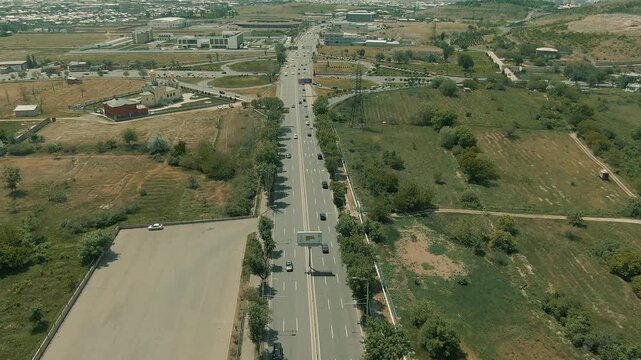 Aerial view of a busy city cloverleaf interchange. Cars move smoothly over the bridge, representing modern urban infrastructure, connectivity, traffic flow, and rapid transportation.