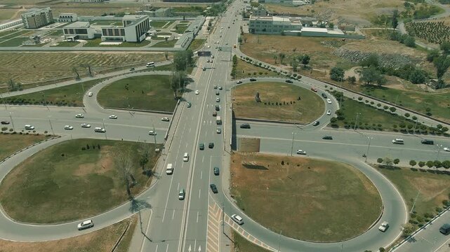 Aerial view of a busy city cloverleaf interchange. Cars move smoothly over the bridge, representing modern urban infrastructure, connectivity, traffic flow, and rapid transportation.