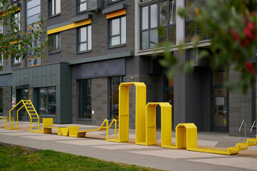 Fototapeta premium yellow outdoor structure in vibrant urban setting, modern architecture background, creative design inviting exploration. perfect for cityscape-themed projects, playful architectural studies