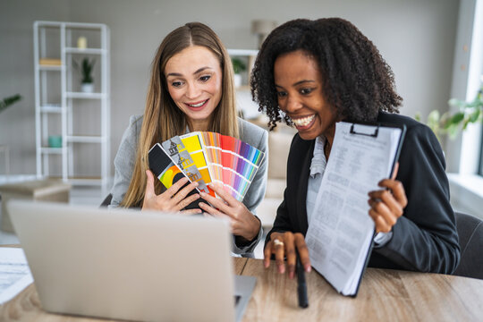 Businesswomen collaborating on video call holding color swatch - Powered by Adobe