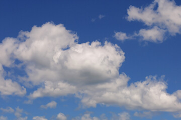 Obraz premium Vibrant Blue Sky with Fluffy White Cumulus Clouds Background