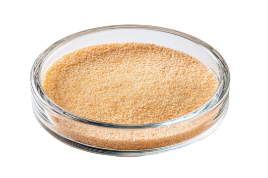 Light orange granular powder in a clear glass petri dish