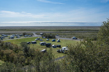 Scenic view of a vibrant camping ground with various RVs and tents set against a serene landscape, showcasing outdoor adventure and nature exploration