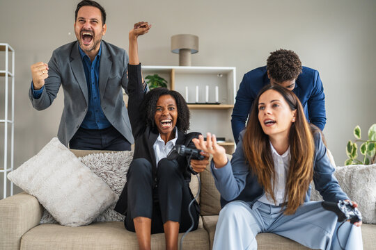 Business colleagues celebrating video game win and loss - Powered by Adobe