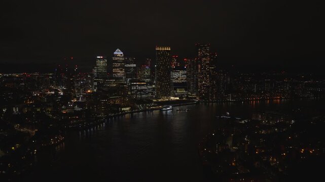 Aerial view of Canary Wharf at night. London financial district illuminated with city lights