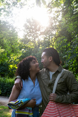 Fototapeta premium Interracial couple walking arm in arm enjoying park