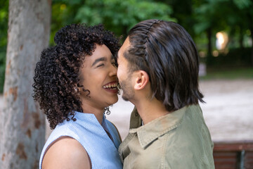 Fototapeta premium Interracial couple laughing in park enjoying happy moment
