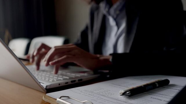 Close-up of female lawyer's hands typing on laptop at law office desk. Legal work and modern justice concept.