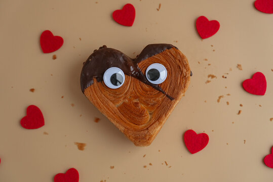 April fool day funny creative eyes on Delicious fresh croissant topped with Dark chocolate flavor Ganache. Creation unique heart shape bakery. Puff pastry holiday love gift present idea Valentine's - Powered by Adobe