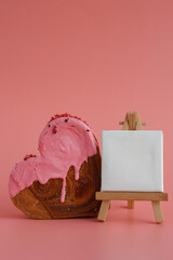 Heart shaped strawberry berry croissant on pink background with copy space. Puff pastry new trendy sweet dessert bakery. Creamy dough experiment 