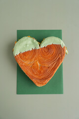 Delightful and vibrant heartshaped pastry croissant treat, beautifully topped with colorful frosting nut galore. Mock up template copy space. Food experimentation viral dessert creative baking trend