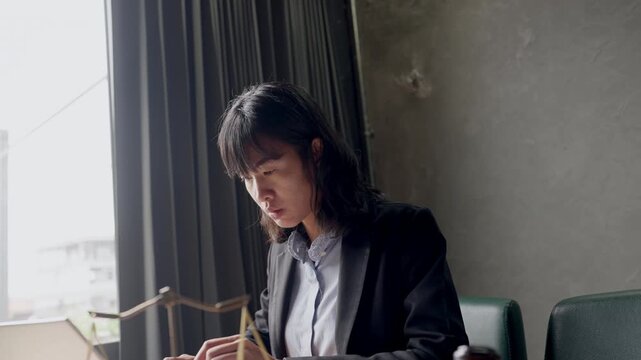Professional female attorney typing on laptop, legal props including gavel and scale visible on desk.