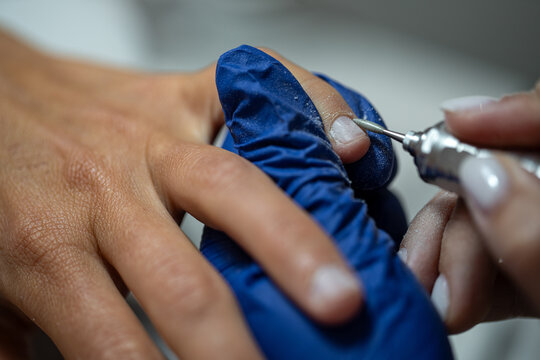 Close-up of nail technician using electric drill for professional manicure treatment - Powered by Adobe