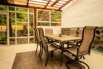Inviting rustic dining space filled with natural light and garden views. Wooden beams and stone textures create a serene, comfortable atmosphere for relaxation and gatherings.