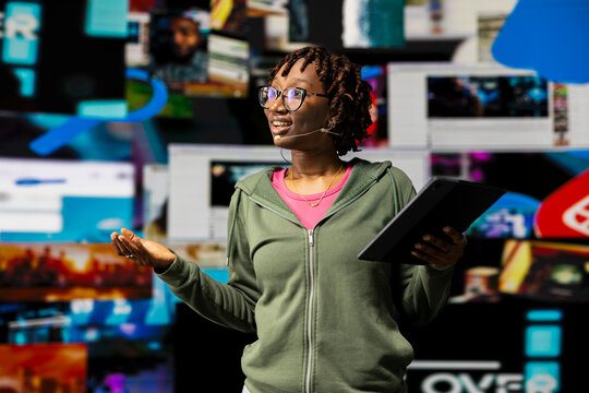 Digital creator doing presentation on social media trends, showing clips on dynamic screen dashboards. Influencer highlighting importance of online engagement and global connection during speech