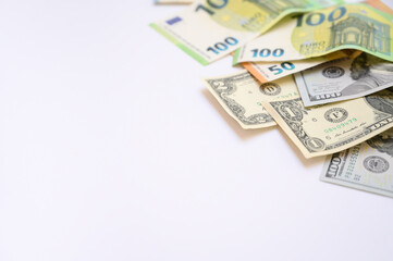 Euro and US dollar banknotes scattered on a white background with copy space. Concept of international finance, currency exchange, business, and global economy suitable for commercial design projects.